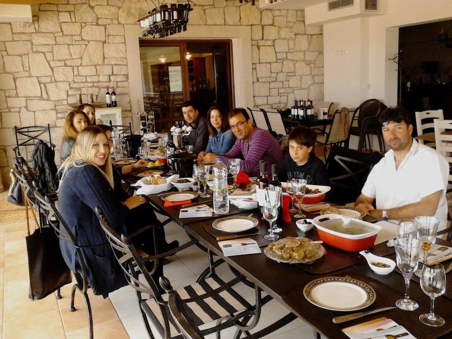 tourists smiling at the camera and eating aperitifs at Domaine Paterianakis and tasting wines